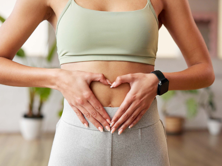 Fitness, heart hands and woman in gym with belly, gut health and inspiration